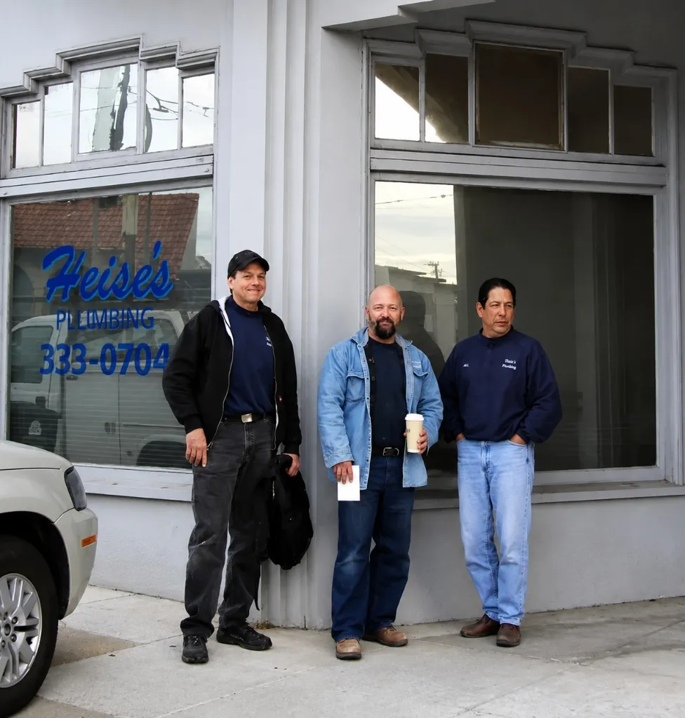 Dave Castillo and crew members standing outside the Heise's Plumbing storefront window