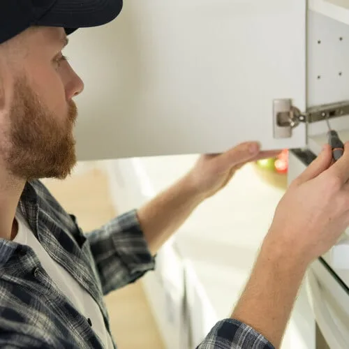 Technician installing cabinet hardware during handyman service in San Francisco
