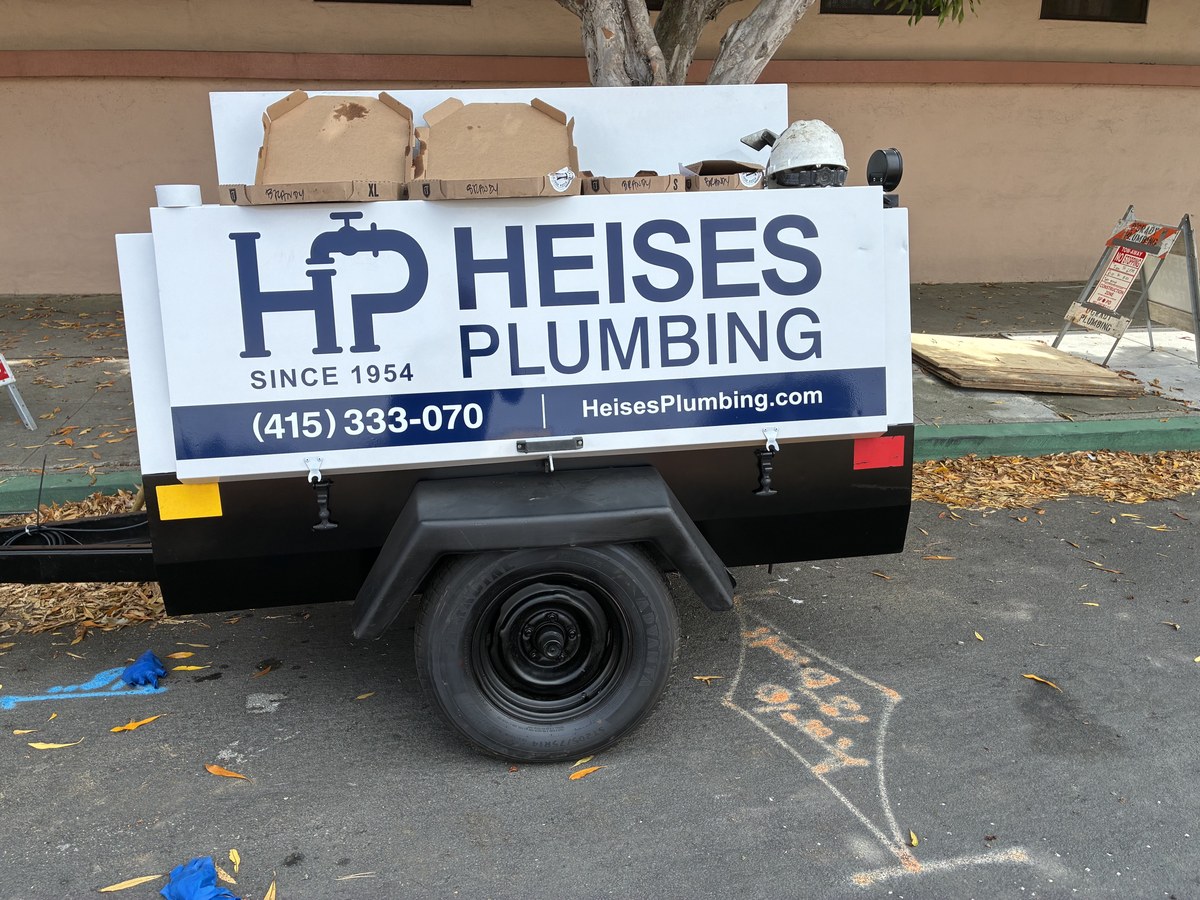 Heise's Plumbing branded utility trailer on site in Pacifica, CA
